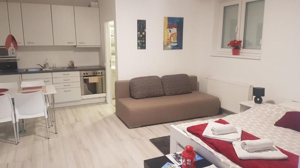 a living room with a couch and a kitchen at Home Away From Home - Apartment Ilica in Zagreb