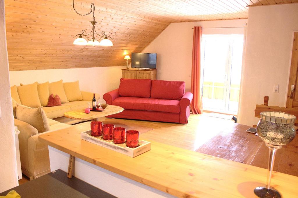 a living room with a red couch and a table at Appartement Landelijke Star in Winterberg