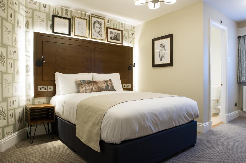 a bedroom with a large bed with a wooden headboard at The Kestrel by Innkeeper's Collection in Harrogate