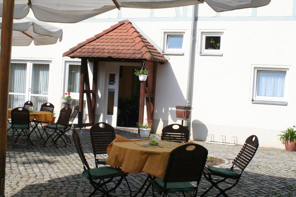 un patio con mesa y sillas y un edificio en Landhotel "Zum Nicolaner", en Großweitzschen