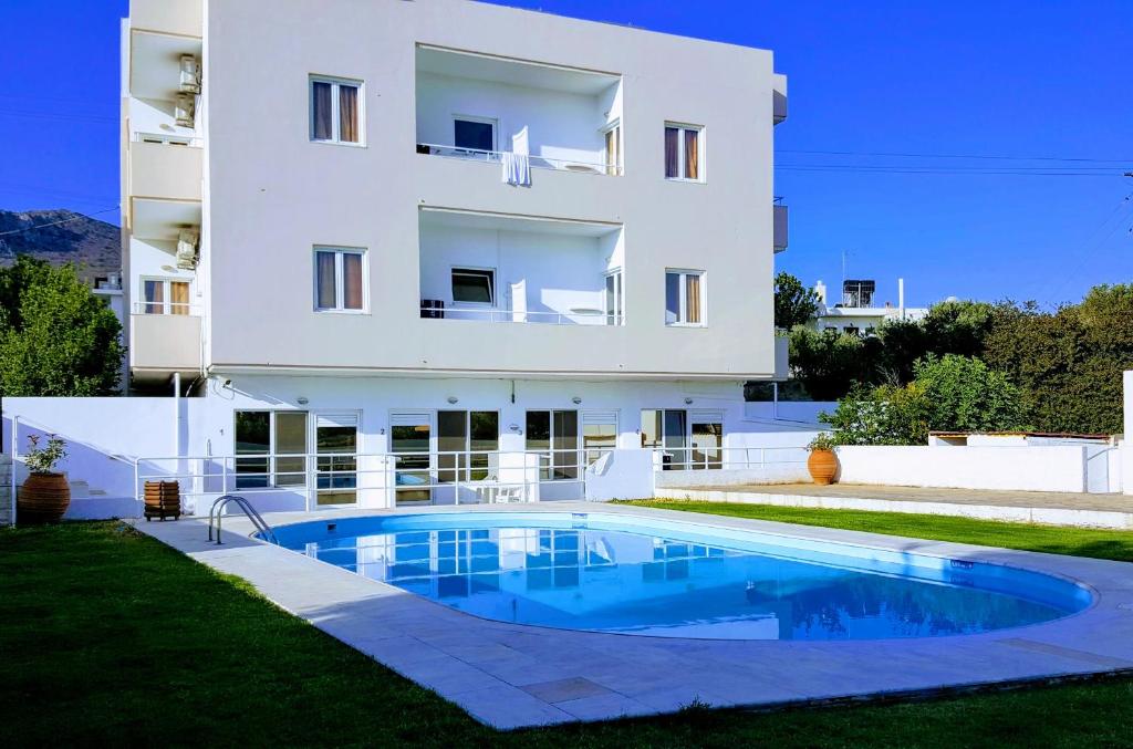 une villa avec une piscine en face d'un bâtiment dans l'établissement Mastorakis Hotel and Studios, à Chersónissos
