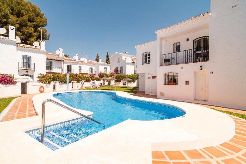 uma villa com piscina em frente a uma casa em Los Pinos 25 Villas Casasol em Nerja