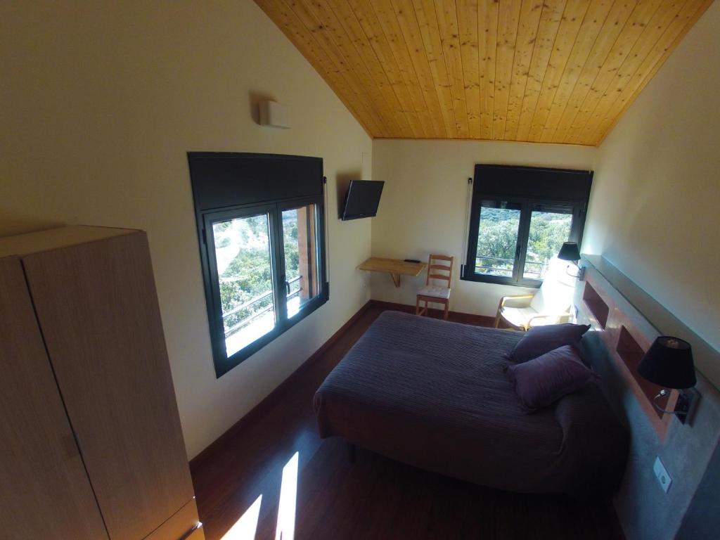 ein Schlafzimmer mit einem Bett und zwei Fenstern in der Unterkunft Hotel Restaurante Port d'Ager in Ager