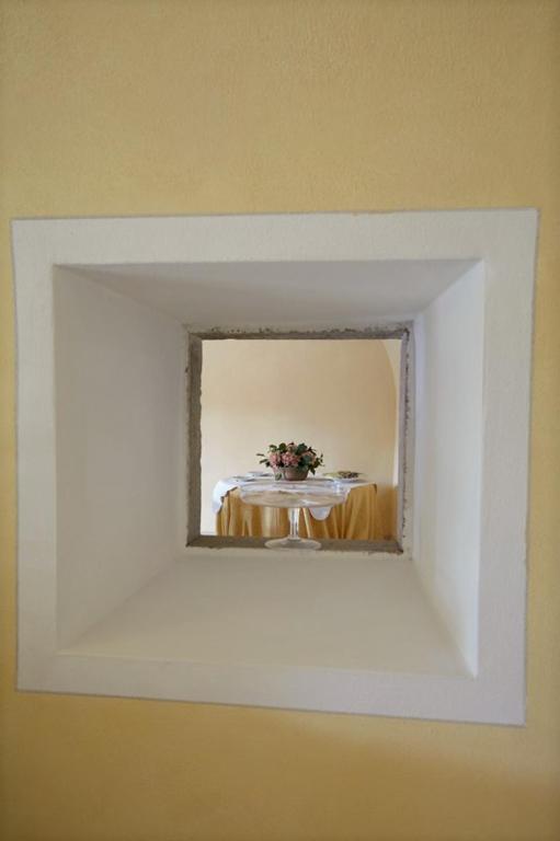 a mirror on a wall with a table in the reflection at Agrigturismo Monte Cicogna in Moniga