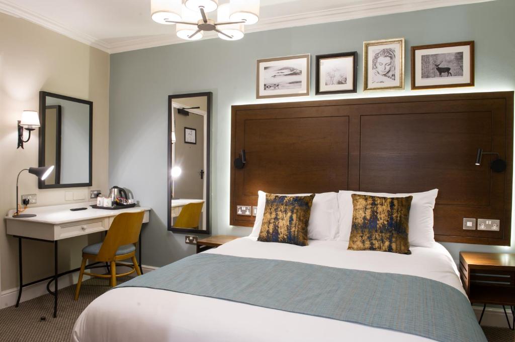 a hotel room with a bed and a desk and a sink at Balloch House by Innkeeper's Collection in Balloch