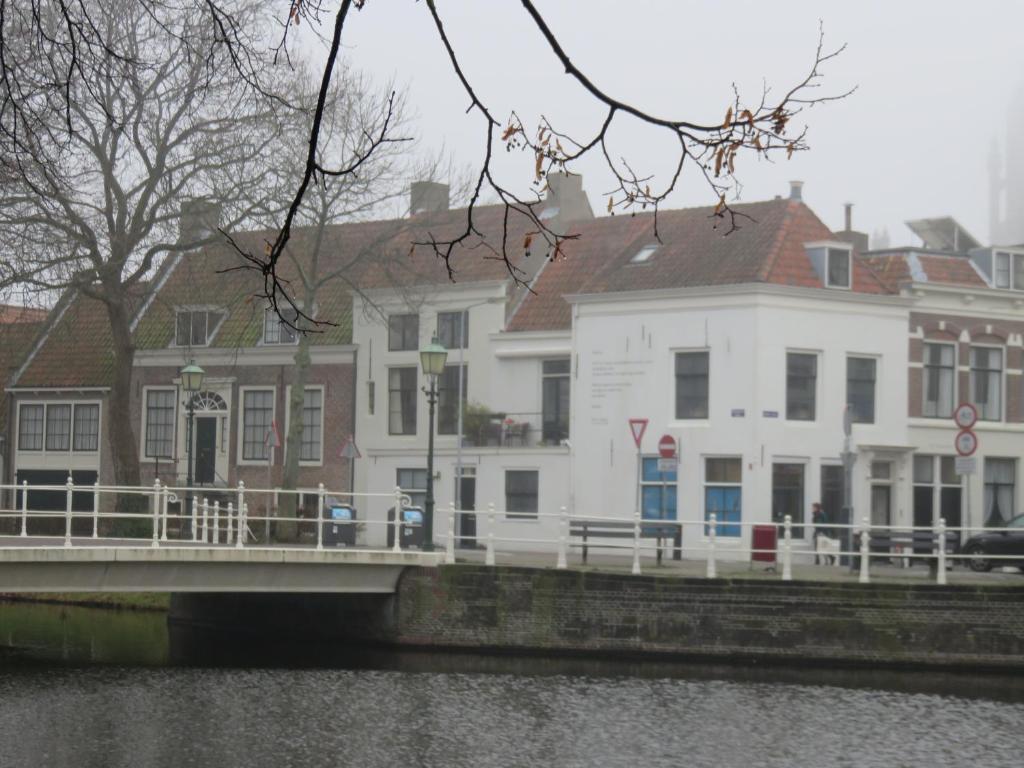 een wit gebouw naast een brug over een rivier bij Kromme weele 26 in Middelburg
