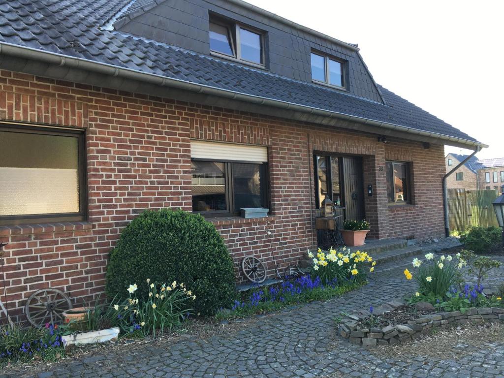 una casa di mattoni con dei fiori di fronte di Ferienwohnung Niederrhein-Oase a Kevelaer
