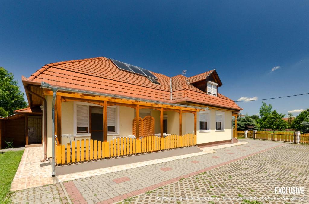 uma pequena casa amarela com um telhado vermelho em Barbara Apartmanház em Kehidakustány