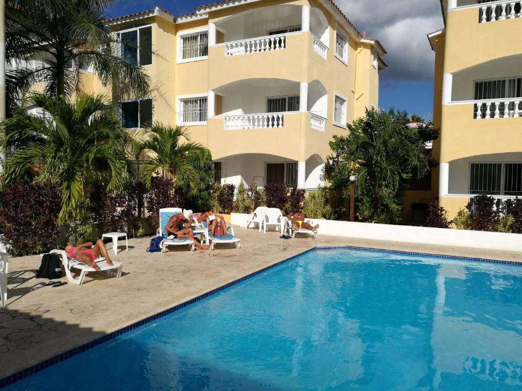 un hotel con piscina frente a un edificio en Tropical Caribe, en Bayahibe