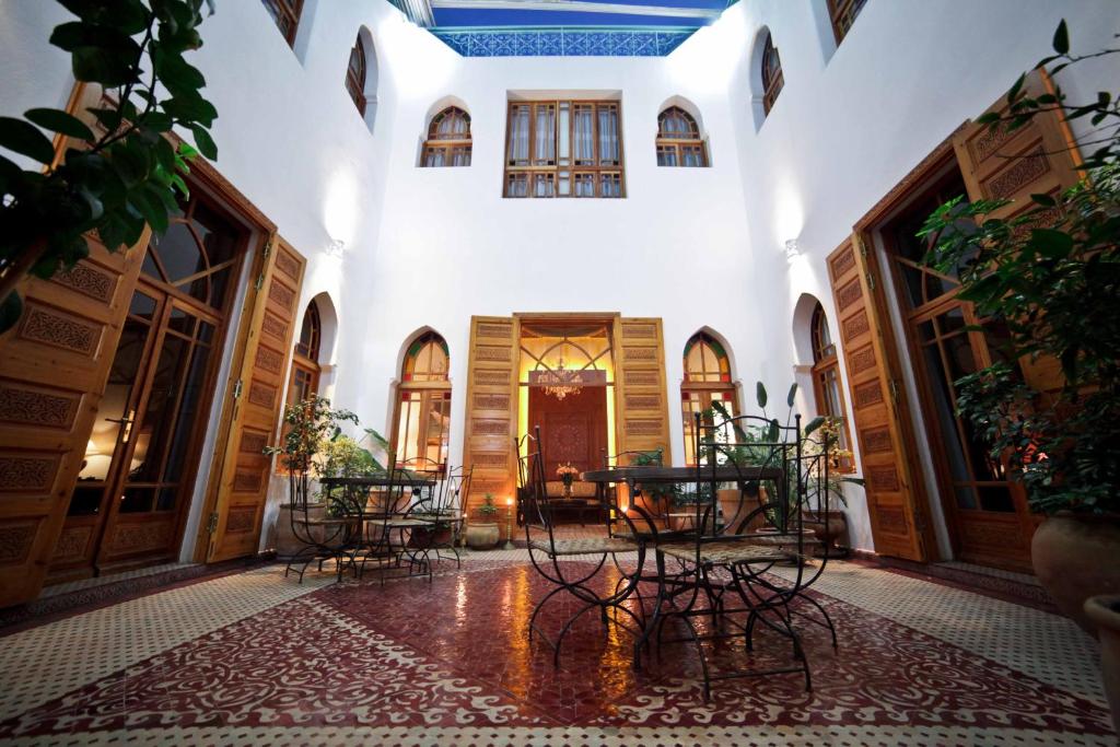 un corridoio con tavoli e sedie in un edificio di Riad Dar Karima a Rabat