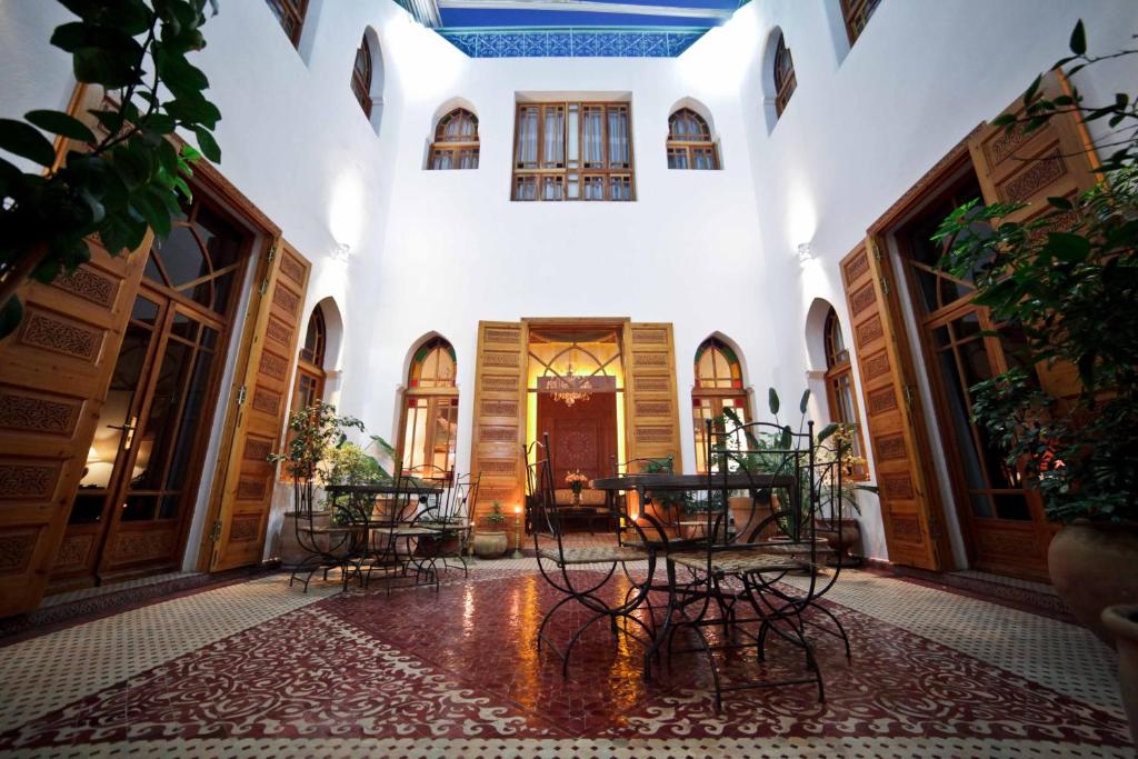 un couloir avec des tables et des chaises dans un bâtiment dans l'établissement Riad Dar Karima, à Rabat