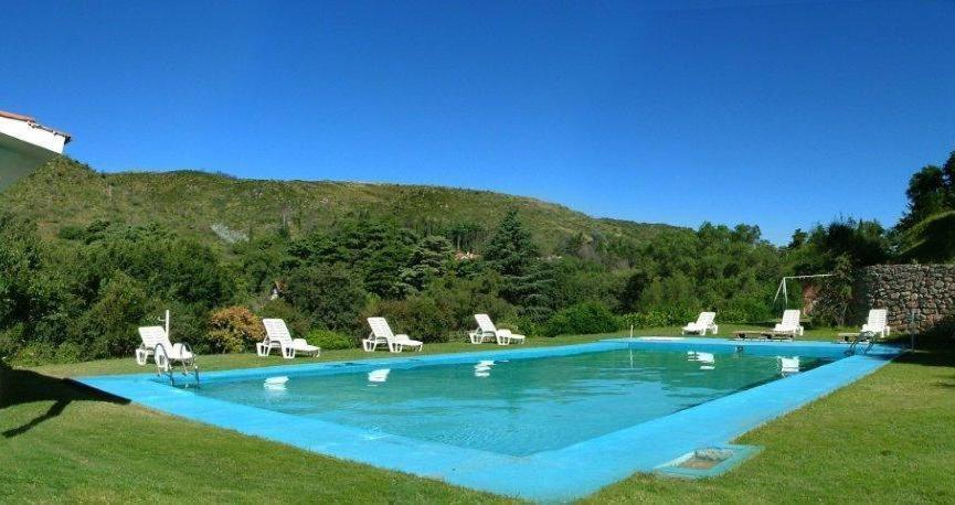 une piscine bleue avec des chaises et une montagne dans l'établissement Gran Hotel La Cumbre, à La Cumbre