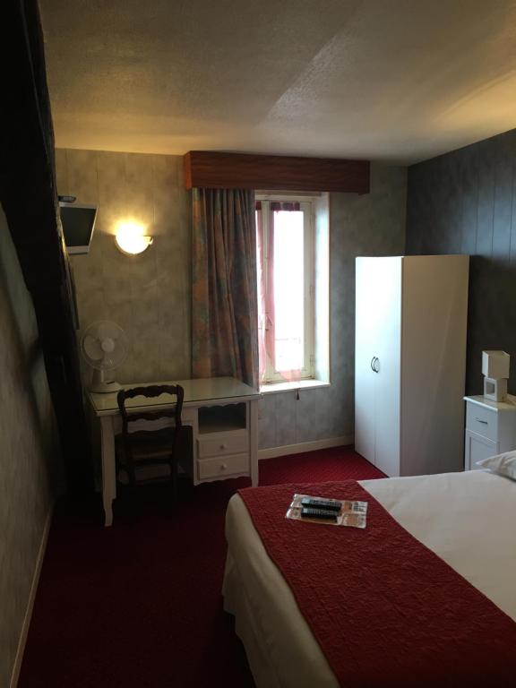 a hotel room with a bed and a desk and a refrigerator at Hotel du Rempart in Sancerre