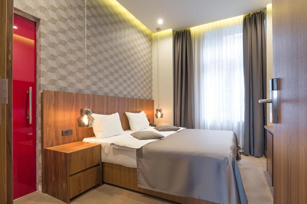 a hotel room with a bed and a window at Five Points Square - City Center in Belgrade