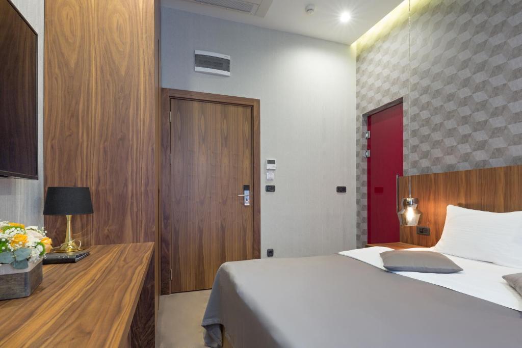 a bedroom with a white bed and a red door at Five Points Square - City Center in Belgrade