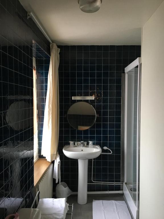 a bathroom with a sink and a mirror at Hotel du Rempart in Sancerre