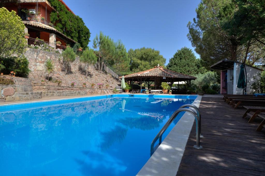 a blue swimming pool with a gazebo at Agriturismo Al Poggetto in Piana degli Albanesi