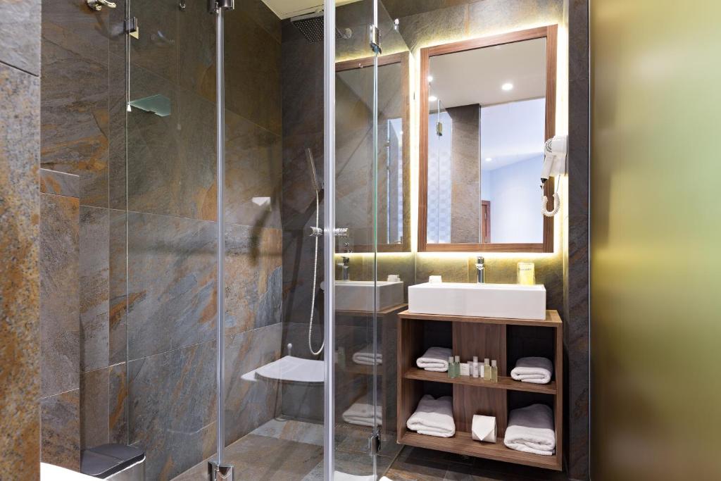 a bathroom with a shower and a sink and a mirror at Five Points Square - City Center in Belgrade