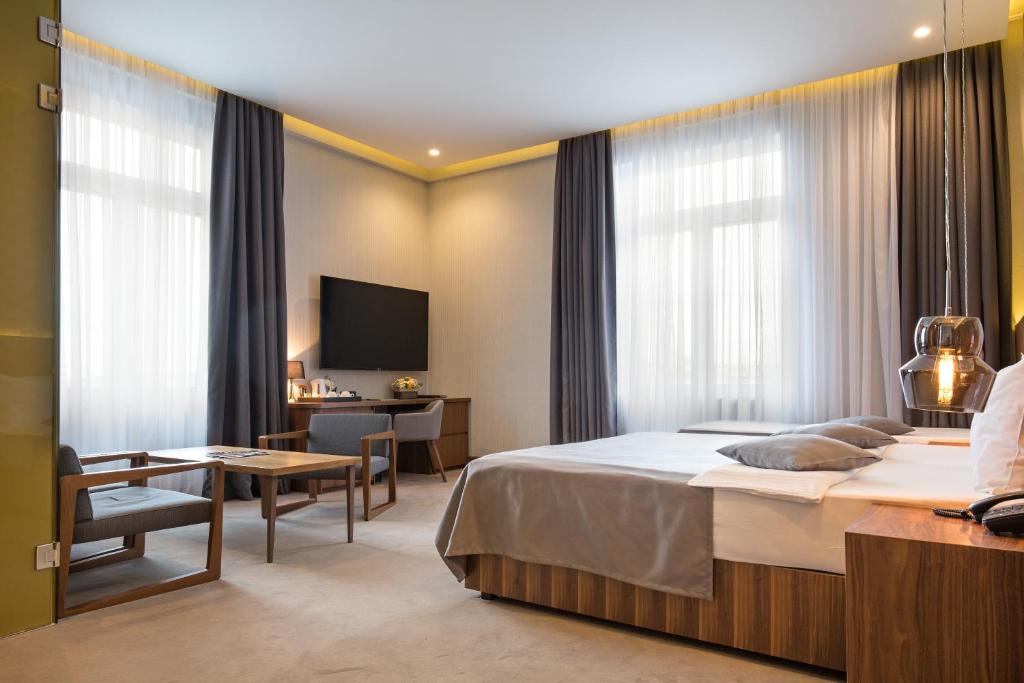 a hotel room with a bed and a desk at Five Points Square - City Center in Belgrade