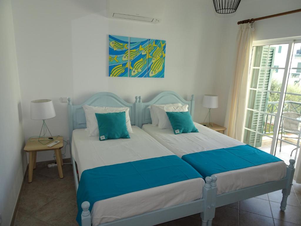カバナス・デ・タビラにあるPetit Poissonのベッドルーム1室(青と白の枕が備わるベッド1台付)
