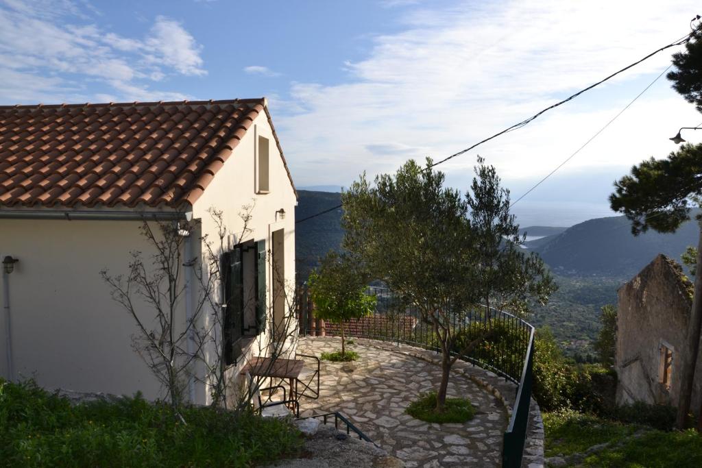 Casa blanca con mesa y sillas en una colina en Fassoulou's cottage en Exoyí