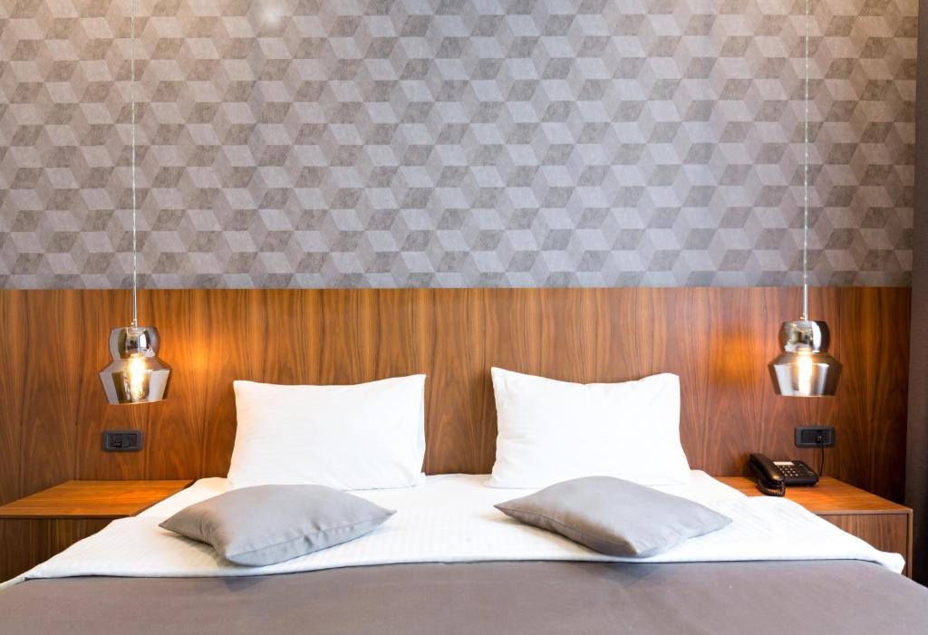 a bed with white sheets and pillows in a room at Five Points Square - City Center in Belgrade