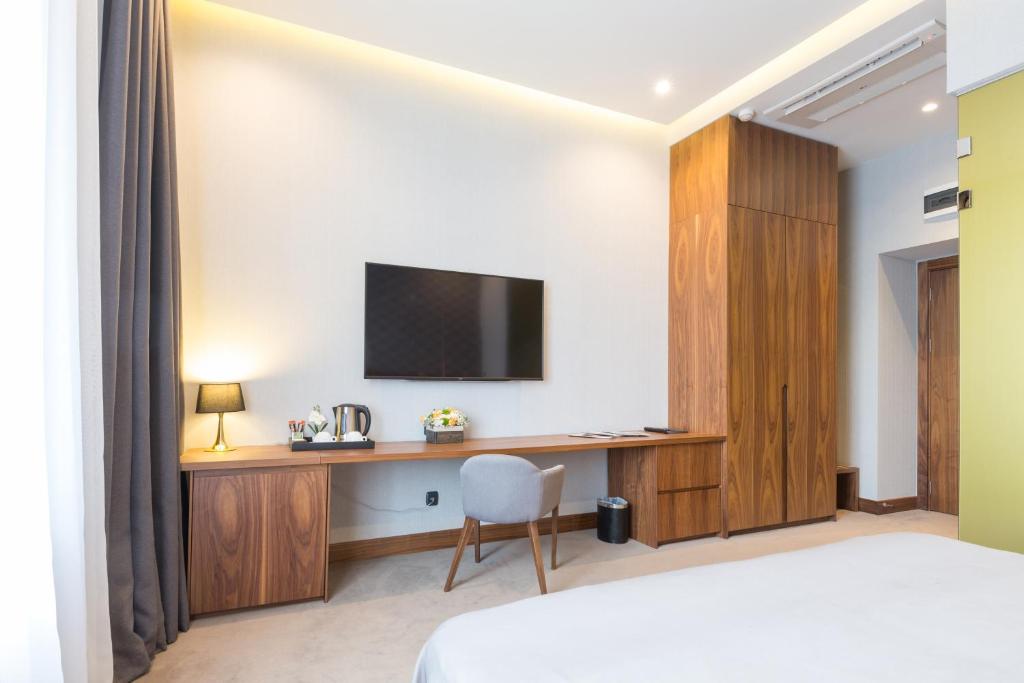 a bedroom with a desk and a tv on a wall at Five Points Square - City Center in Belgrade
