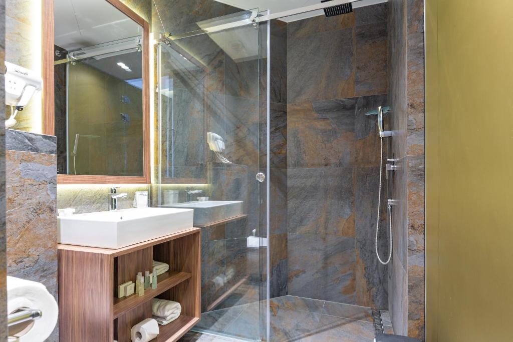 a bathroom with a sink and a glass shower at Five Points Square - City Center in Belgrade