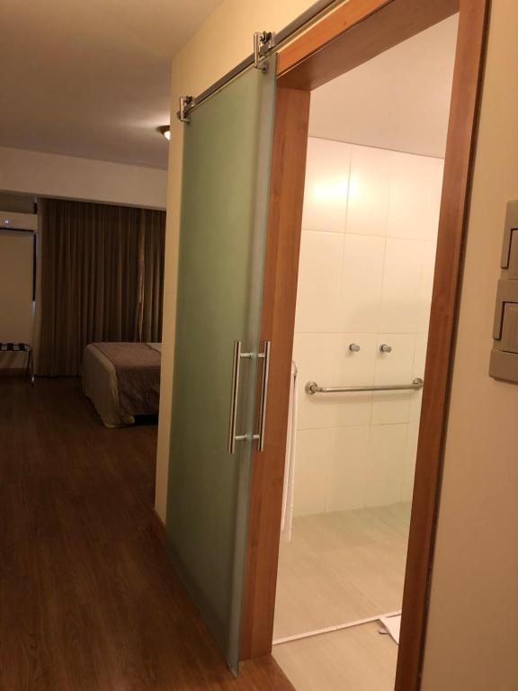 una puerta corredera de cristal en una habitación con 1 dormitorio en Gran Continental Hotel Taubaté, en Taubaté