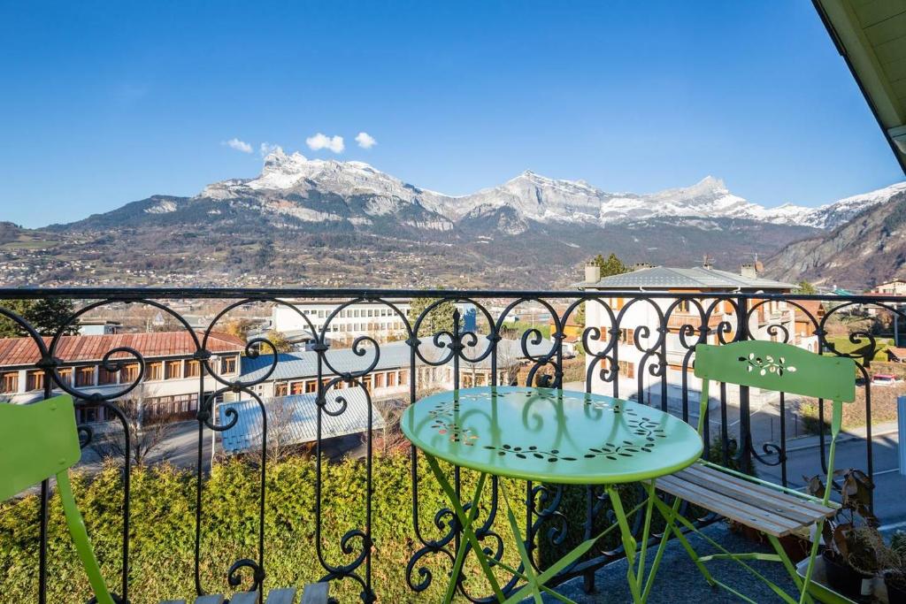 ein Balkon mit Tisch und Blick auf die Berge in der Unterkunft Les Fourges in Saint-Gervais-les-Bains
