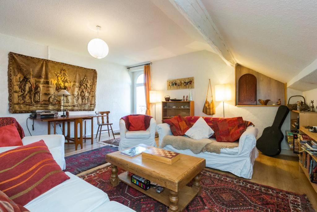 uma sala de estar com sofás brancos e uma mesa em Les Fourges em Saint-Gervais-les-Bains