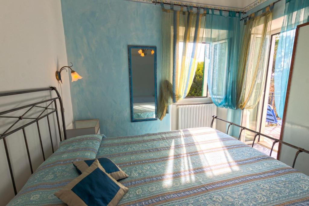 シローロにあるCamere Alisaのベッドルーム1室(青い壁のベッド1台、窓付)