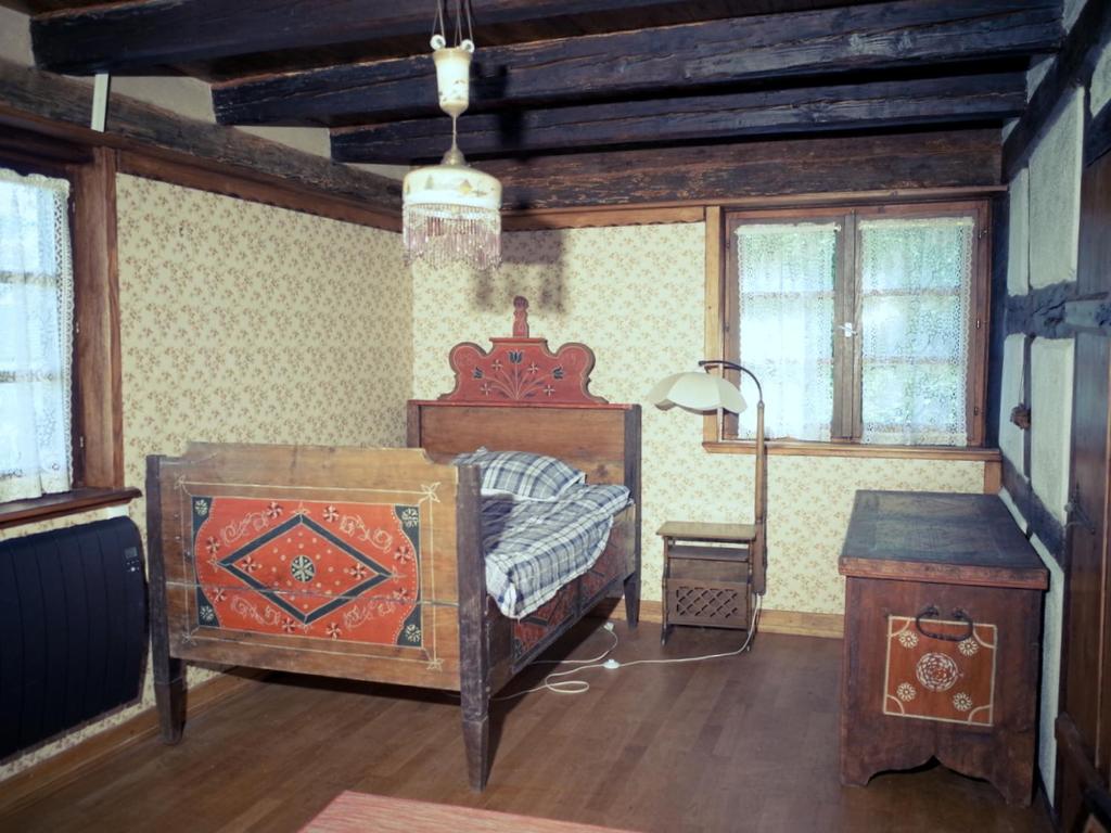 um quarto com uma cama, uma mesa e janelas em Maison alsacienne em Eschau