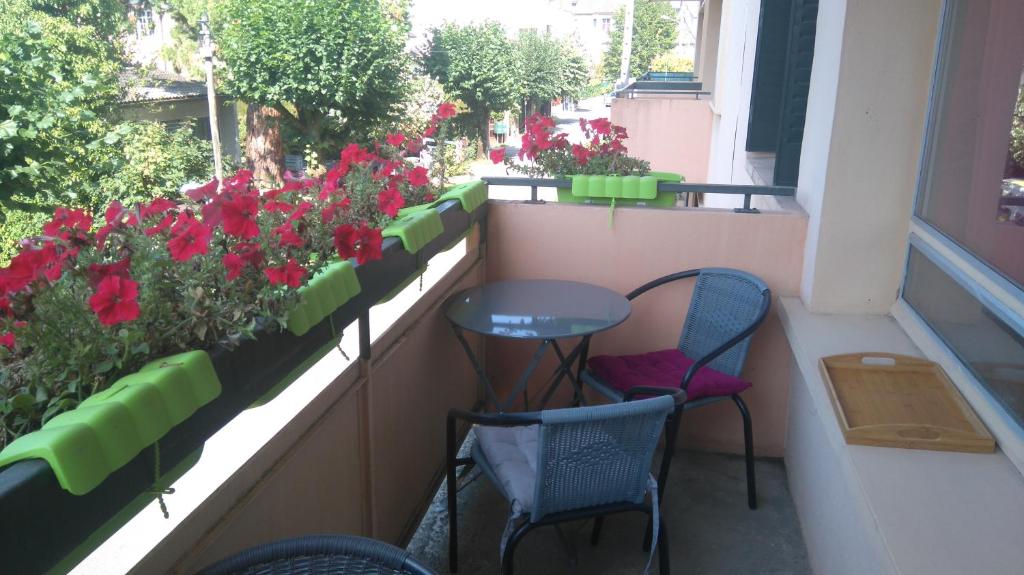 un balcone con 2 sedie, un tavolo e fiori di Turgot a Thonon-les-Bains