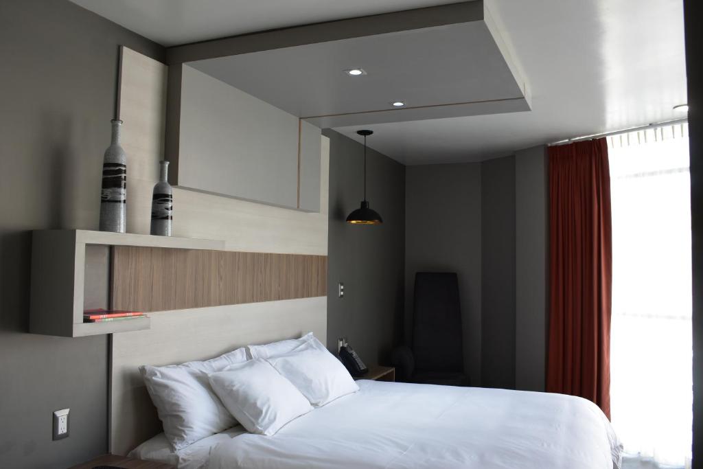 Postel nebo postele na pokoji v ubytování ESDUMA HK HOTEL Pachuca