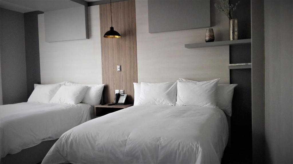 Postel nebo postele na pokoji v ubytování ESDUMA HK HOTEL Pachuca