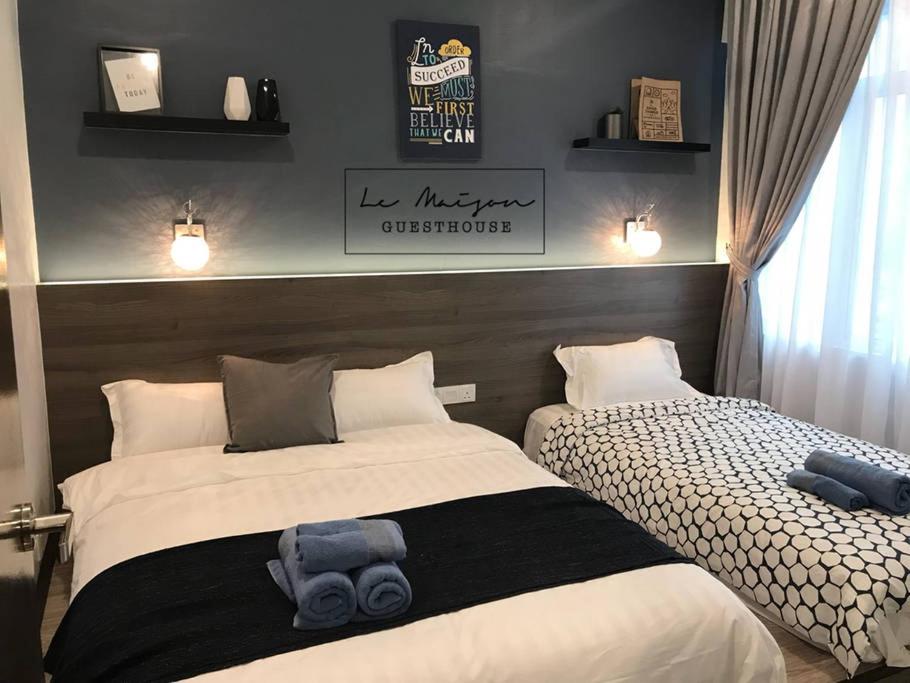 a bedroom with two beds with a blue teddy bear on it at Le Maison GuestHouse @ Majestic Imperial in Ipoh