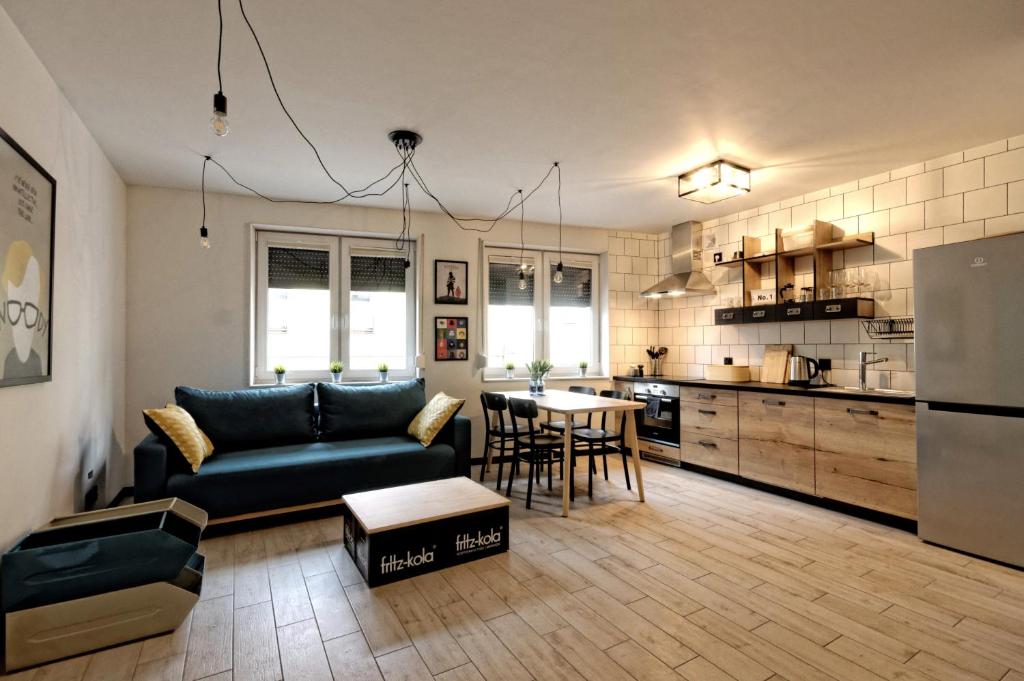 Il comprend un salon et une cuisine avec un canapé et une table. dans l'établissement Industrialny Kwadrat, à Złotów