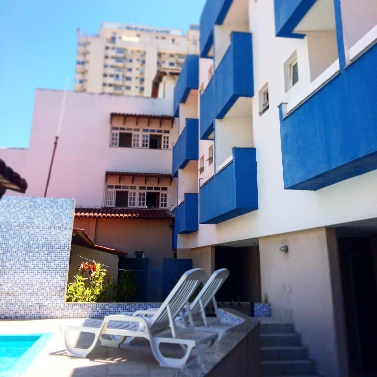 a pair of chairs sitting on the side of a building at Hotel Marlin Azul in Vila Velha