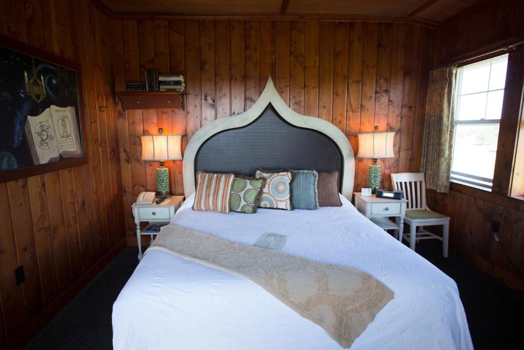 a bedroom with a large bed with wooden walls at McMenamins Gearhart Hotel in Gearhart