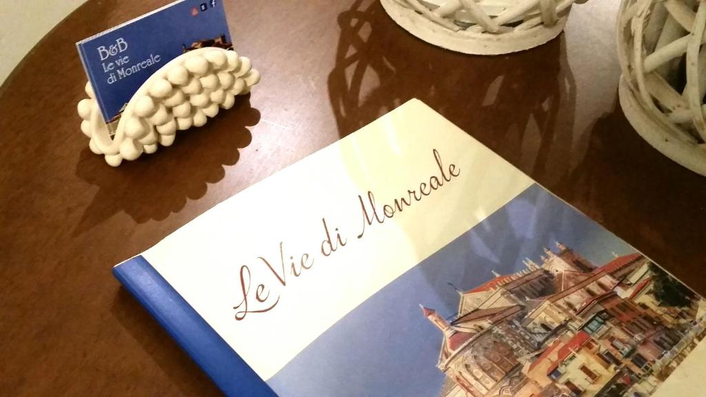 モンレアーレにあるLe Vie di Monrealeの雑誌の横のテーブルに座る本