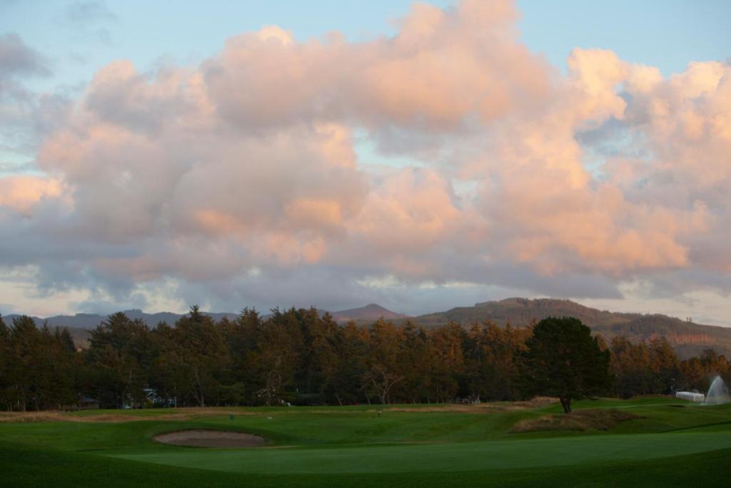 a view of a golf course with a cloudy sky at McMenamins Gearhart Hotel in Gearhart