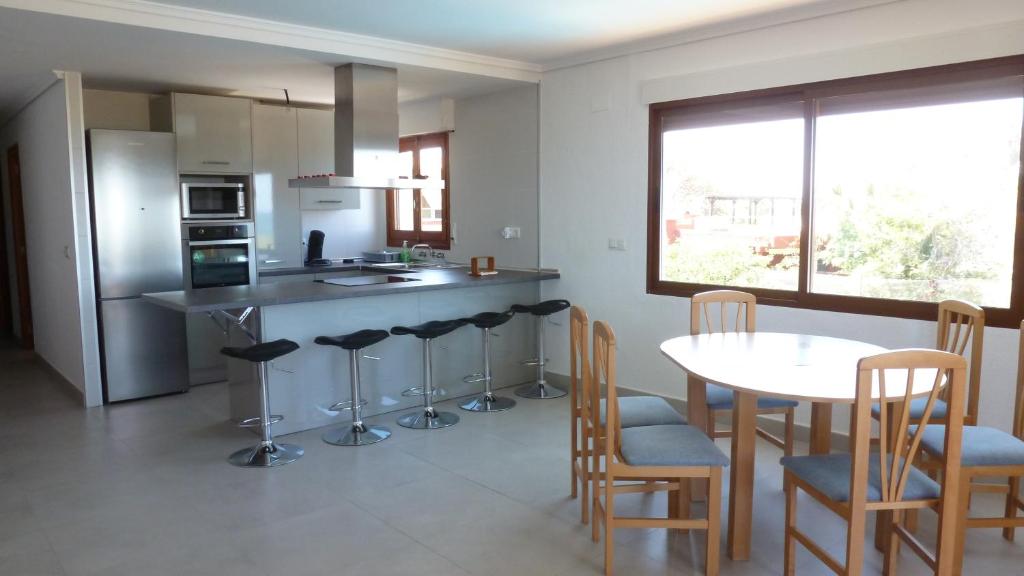 a kitchen with a table and chairs and a table and a counter at Casa Playa in Tavernes de Valldigna