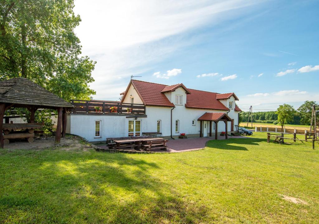 a house with a picnic table and a gazebo at Gospodarstwo Agroturystyczne AGRO-WOLICE in Wolice