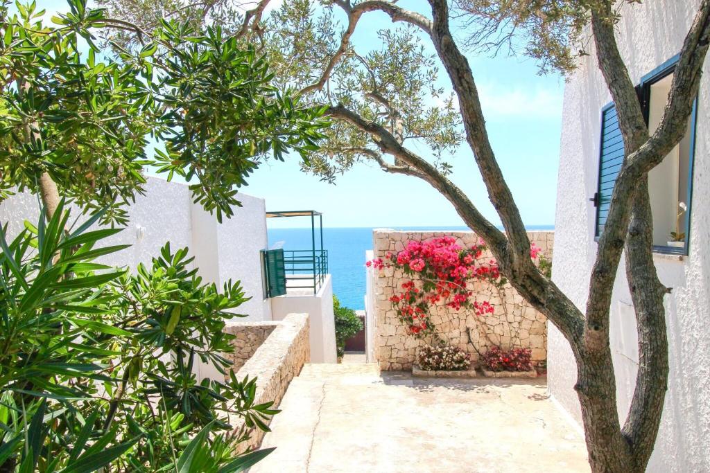 einen Blick auf das Meer von einem Haus mit einem Baum in der Unterkunft Residenza La Cicala in Castro di Lecce