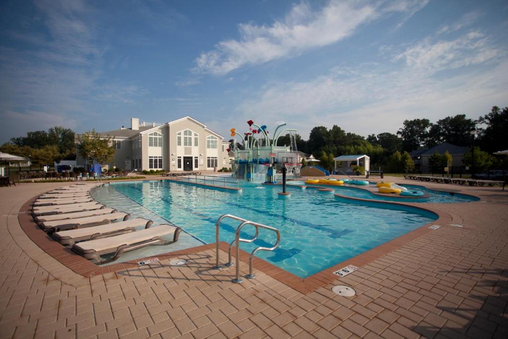 una gran piscina con sillas y un complejo en The Colonies at Williamsburg, en Williamsburg