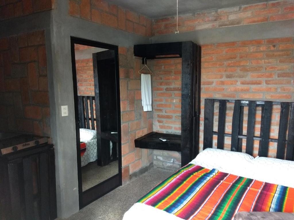 a bedroom with a bed and a brick wall at Posada Don Jose in El Fuerte
