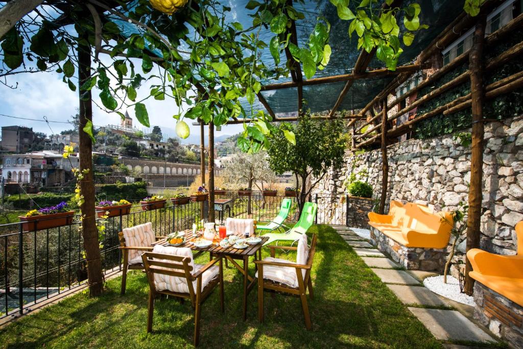 patio con tavolo e sedie sull'erba di Villa Laura amazing breakfast,private outdoor hot tub, Positano experience a Positano