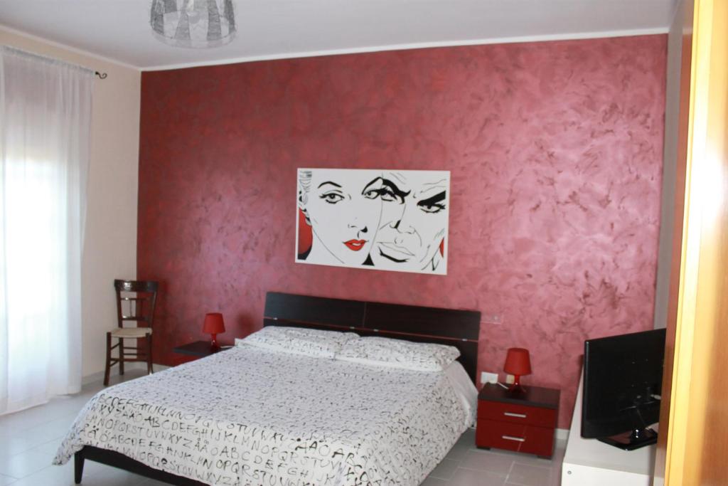 Un dormitorio con una cama y una pared roja. en Bed & Breakfast 21, en Gela