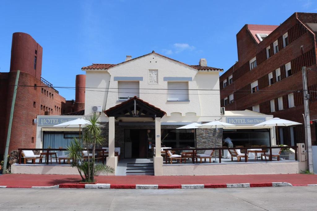 un restaurante con mesas y sombrillas frente a un edificio en Hotel San Diego, en Punta del Este